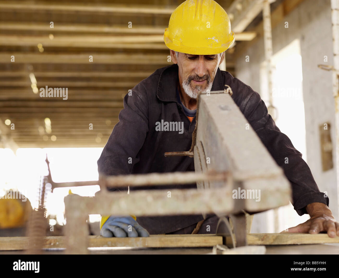 Hispanische Arbeiter mit Säge auf Baustelle Stockfoto