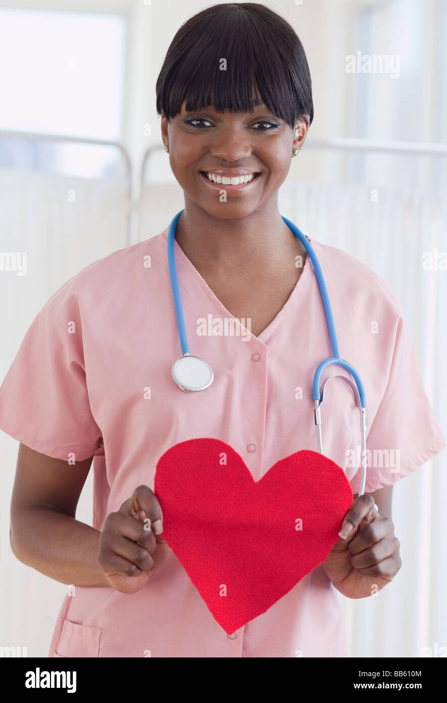 Afrikanischen Krankenschwester hält herzförmige Stück Papier Stockfoto