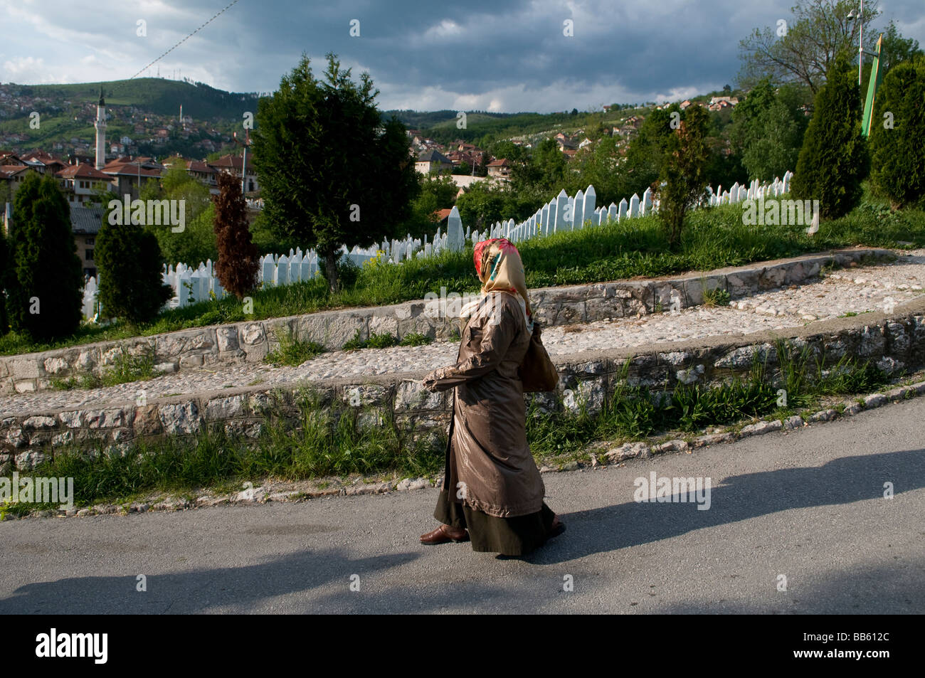 Muslimische Frau passieren Martyrs' Memorial Friedhof Kovaci für die Opfer des Krieges in Stari Gradi Bezirk, Sarajevo Bosnien-Herzegowina Stockfoto