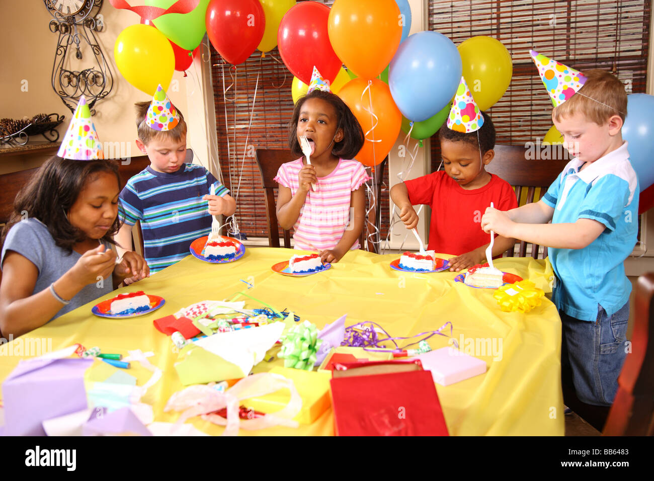 Gruppe von Kindern essen Kuchen auf Geburtstagsparty Stockfoto