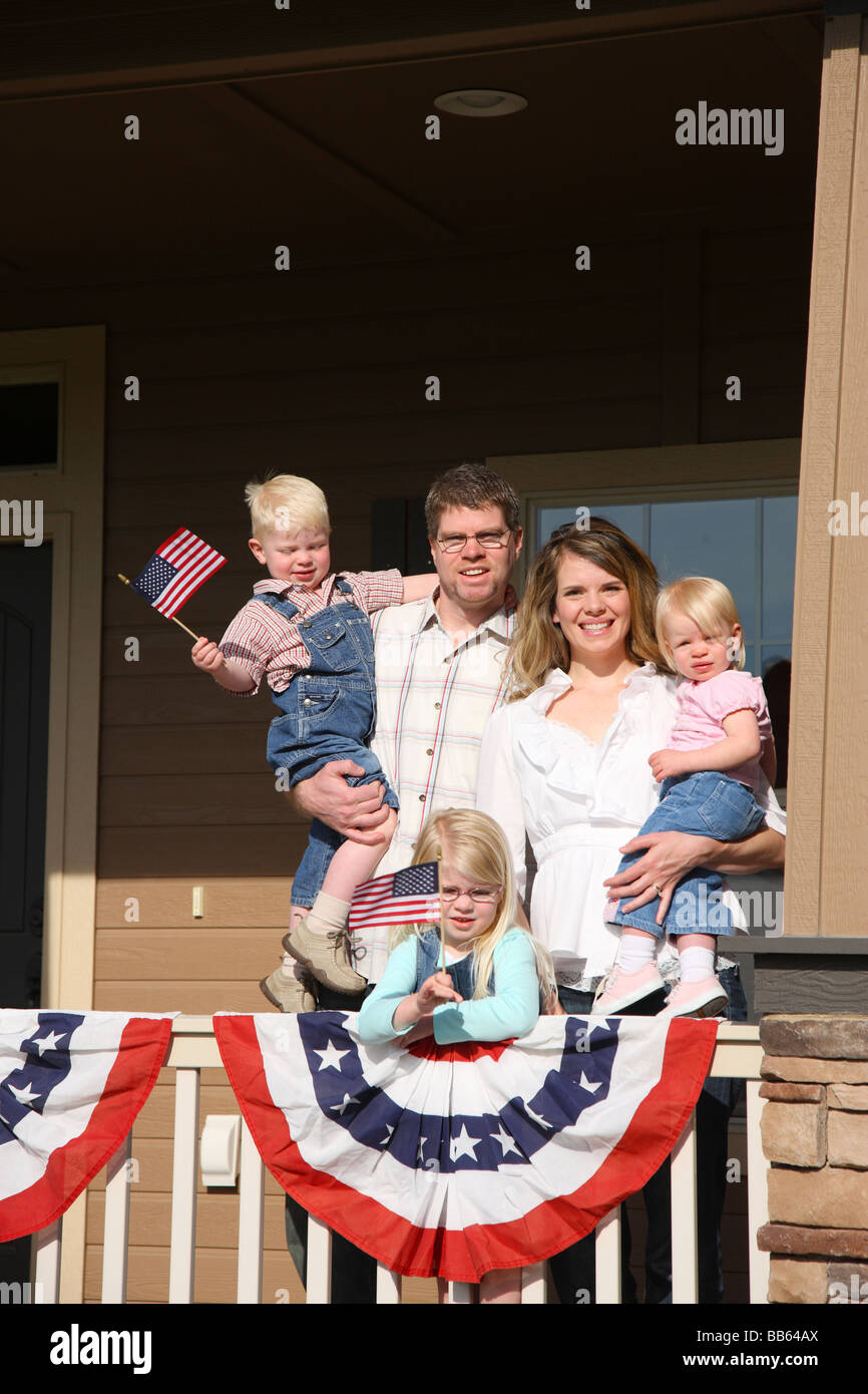 Patriotischen Familie auf Veranda mit Kindern wehende Fahnen Stockfoto