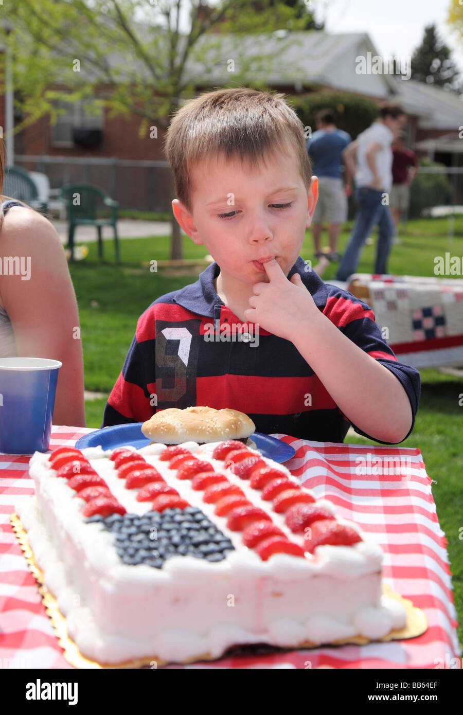 Kleiner Junge Zuckerguss aus patriotischen Kuchen essen Stockfoto