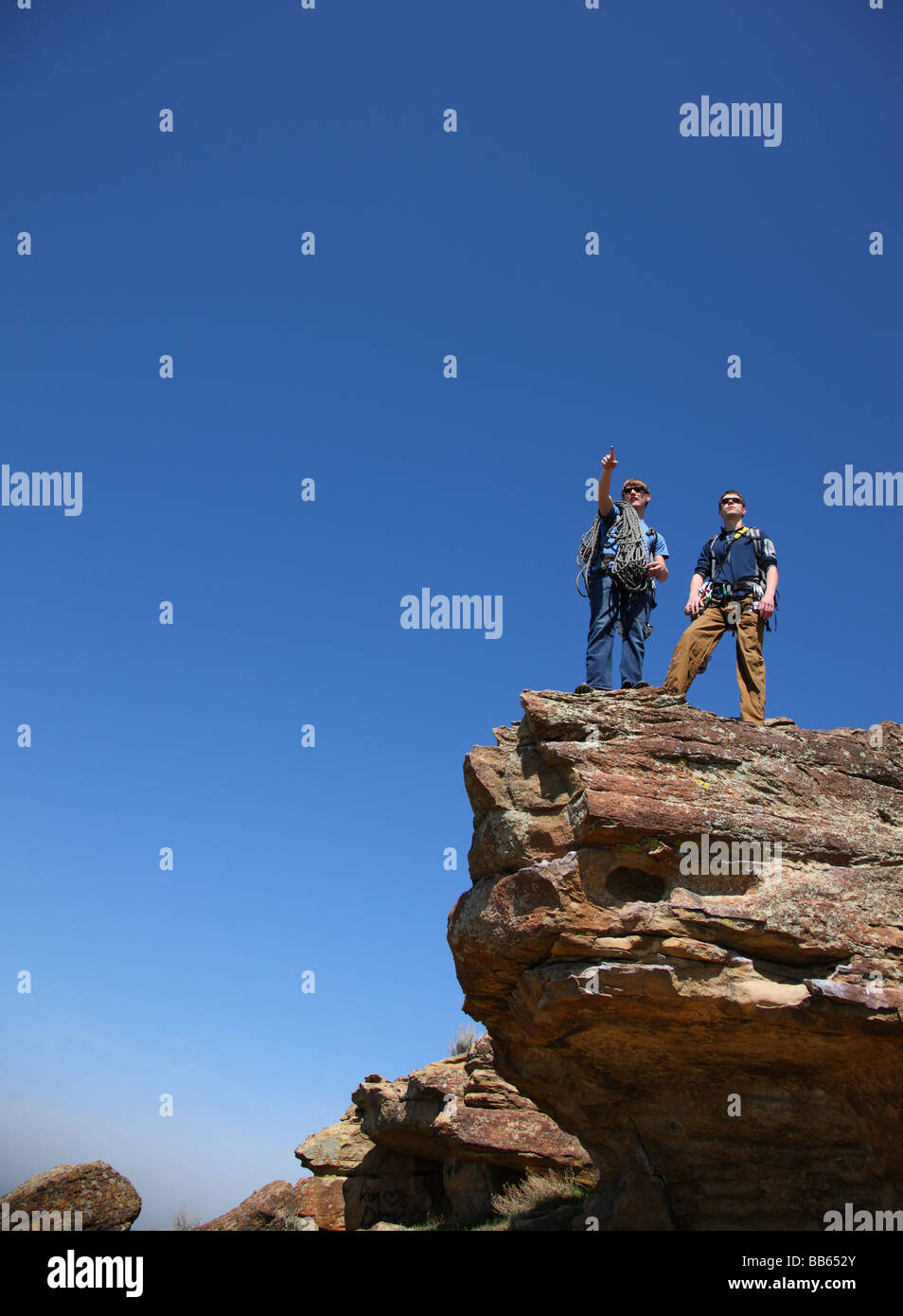Zwei Kletterer stehen auf felsigen Gipfel aufzeigen Stockfoto