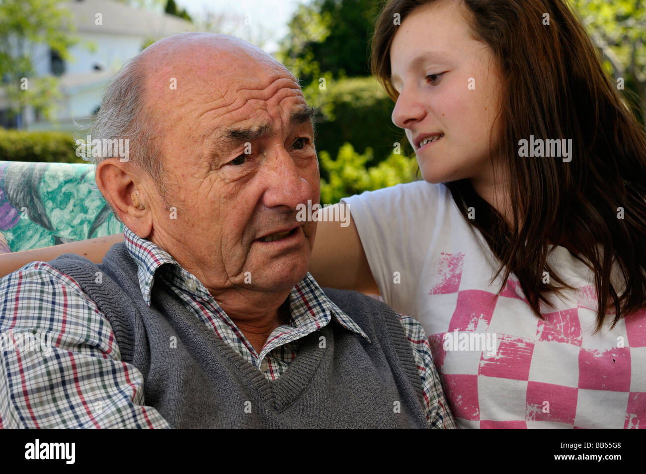 Schwerhörige Grossvater mit Lärmschwerhörigkeit versuchen, Enkelin außerhalb zu verstehen Stockfoto