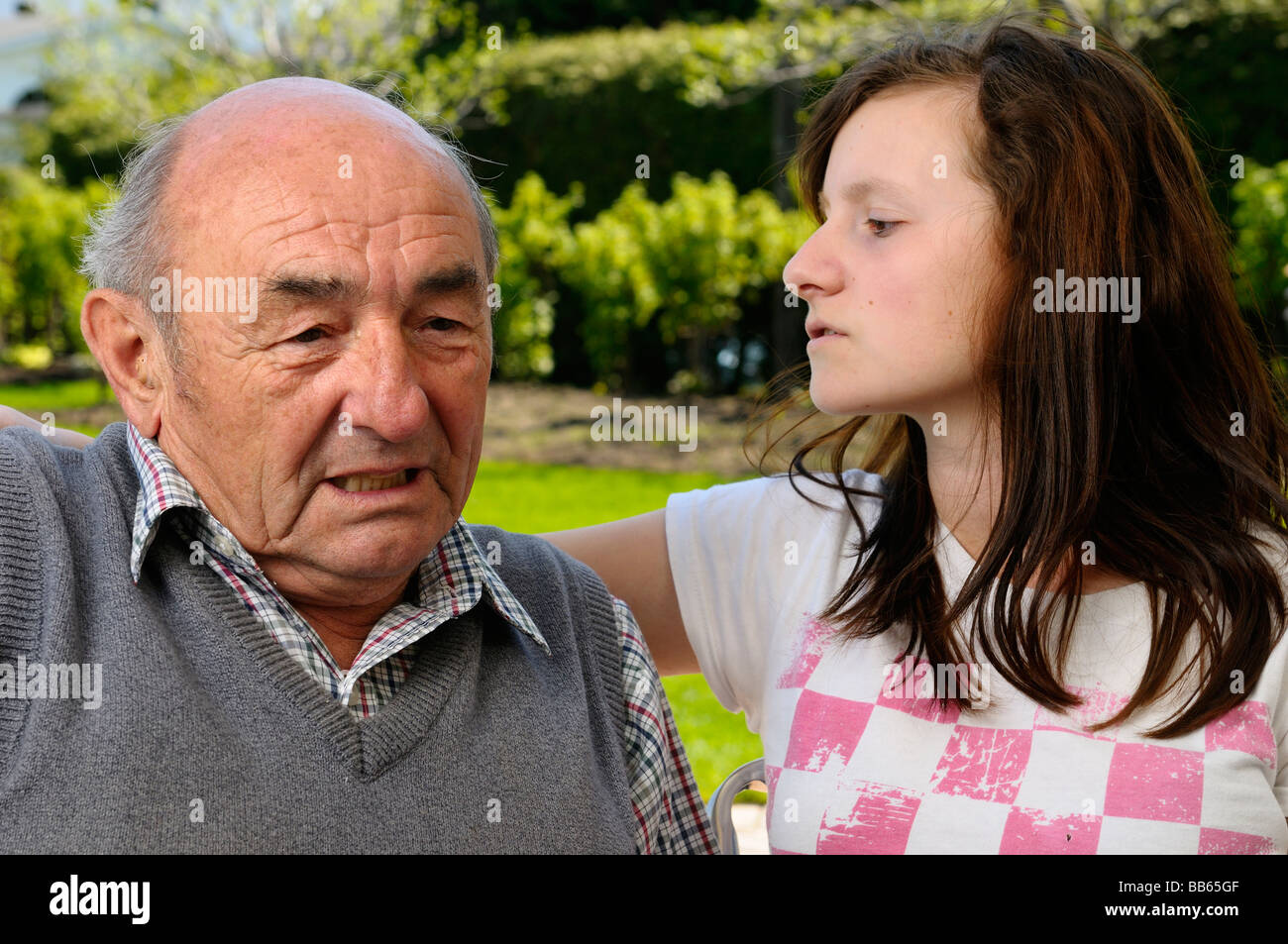 Pensionierte Arbeiter mit Lärmschwerhörigkeit Schwierigkeiten beim Hören außerhalb zu Enkelin Stockfoto