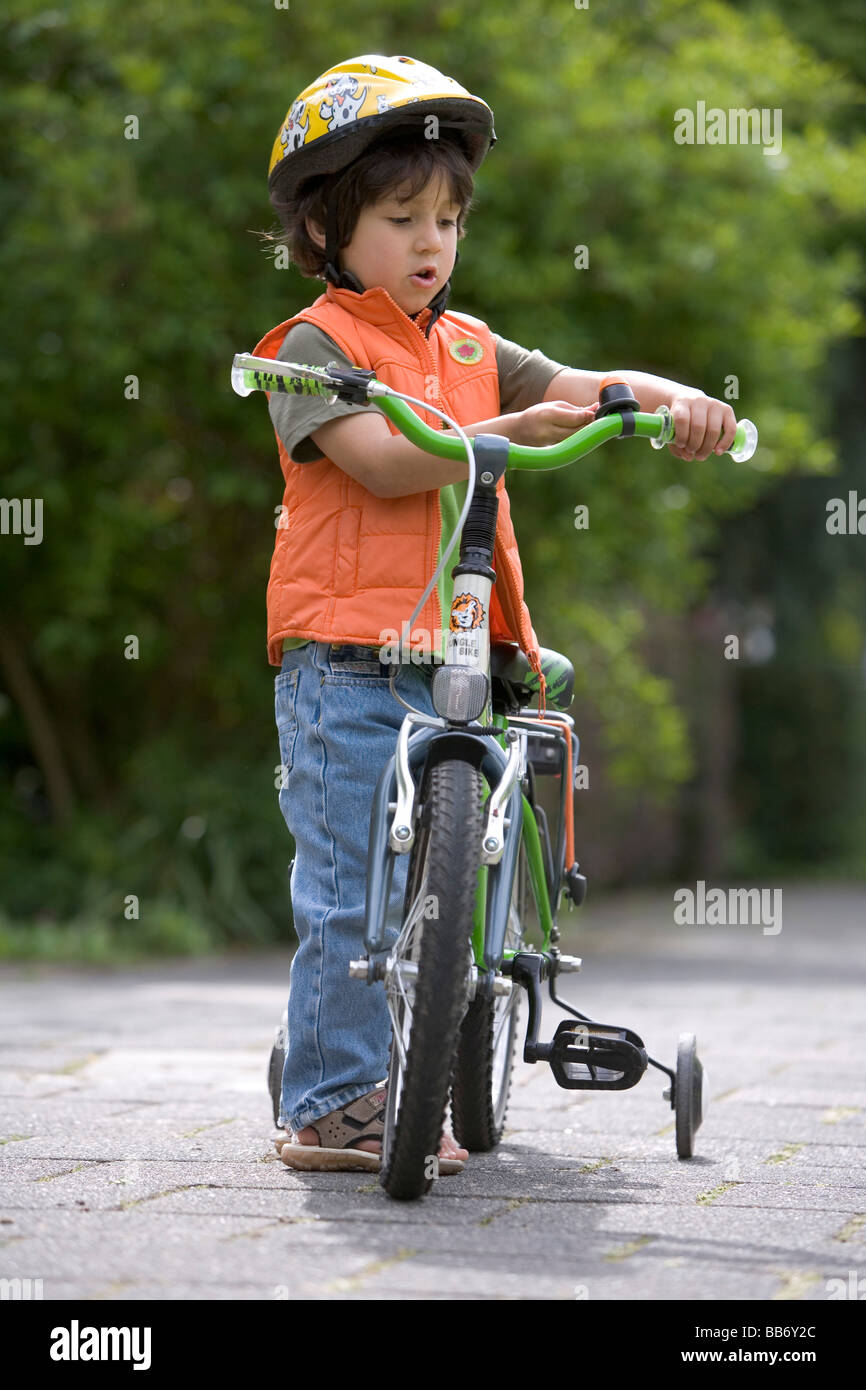 Kleiner Junge mit seinem Fahrrad stehen Stockfoto
