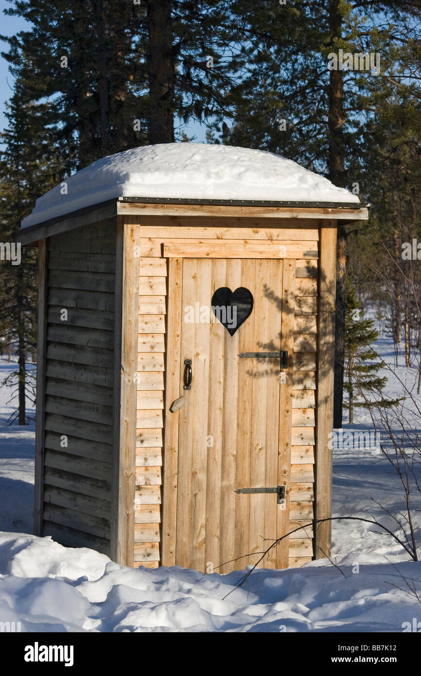 Verschneite Toilette in einem winterlichen Wald in Kiruna, Nordschweden, Schweden Stockfoto