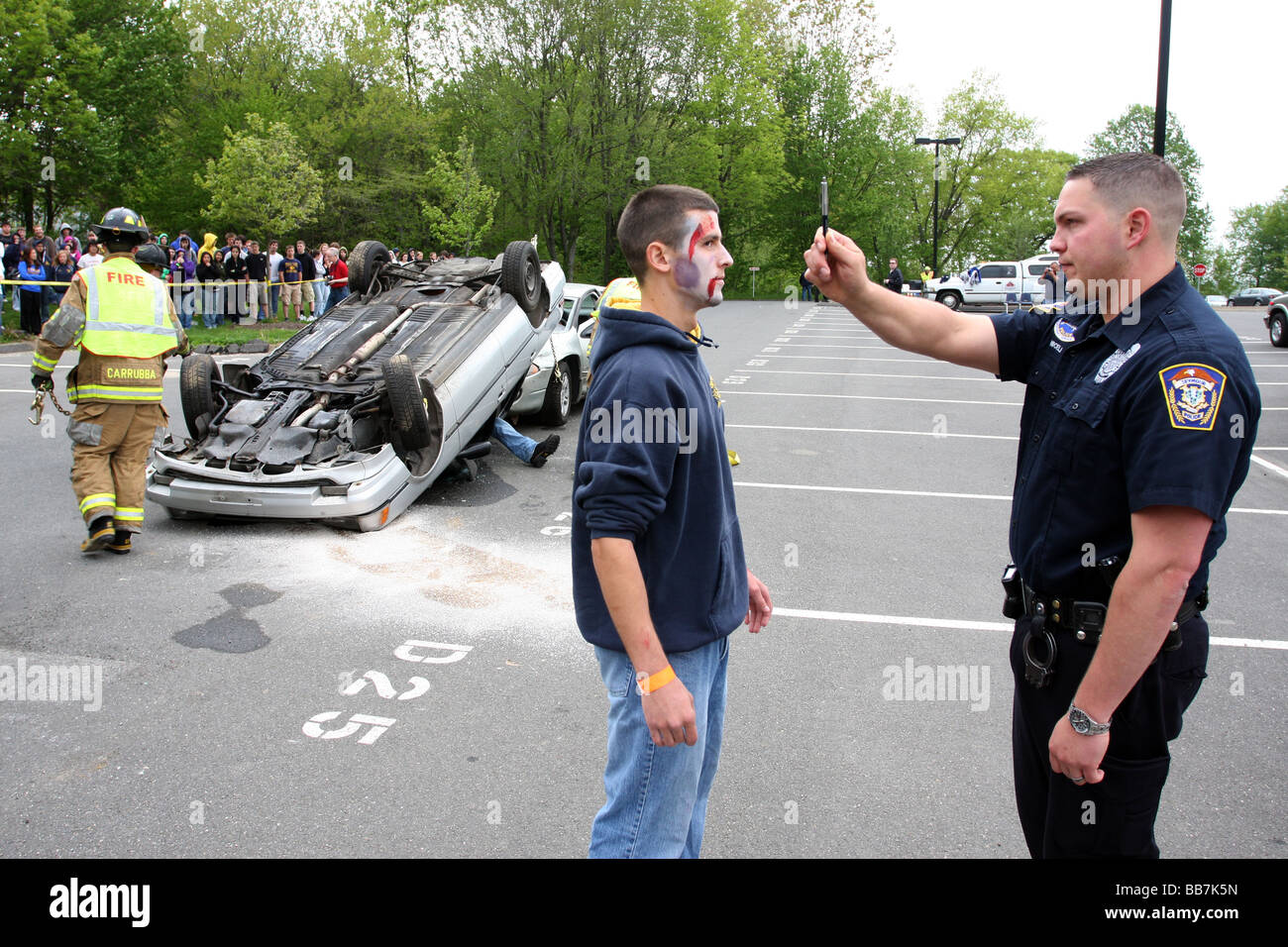 Ein Polizist gibt einem Teenager einen DUI Test während einer simulierten betrunken fahren Unfall an einer High School in USA Stockfoto