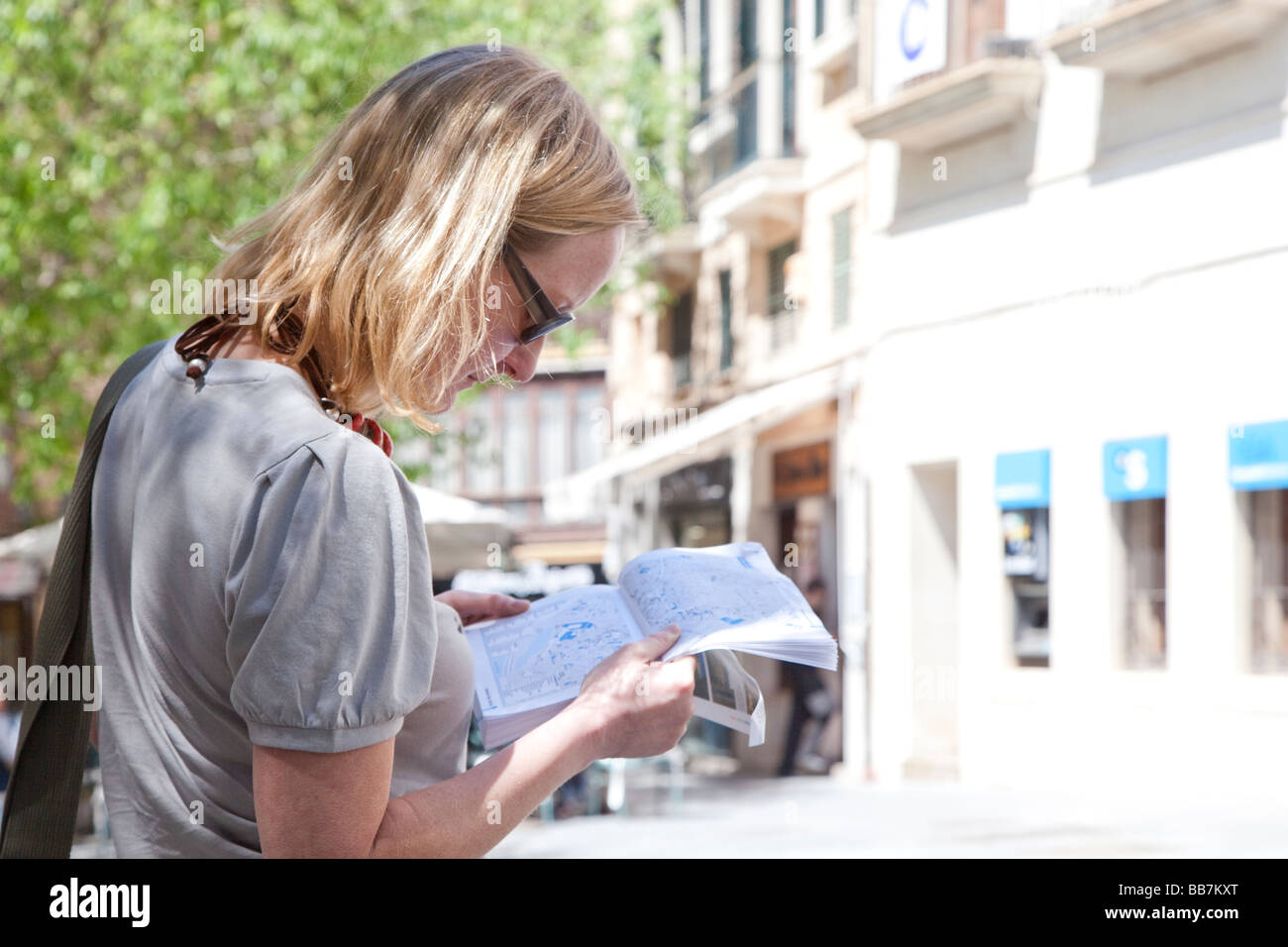 Frau liest Ratgeber in Straße Palma Mallorca Spanien Stockfoto