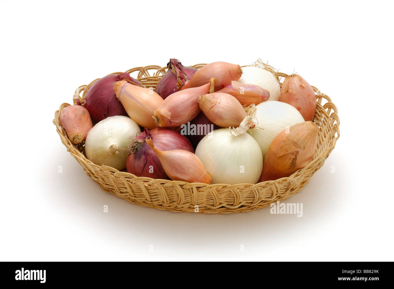 Verschiedene Arten von Zwiebeln in einem geflochtenen Korb Stockfoto