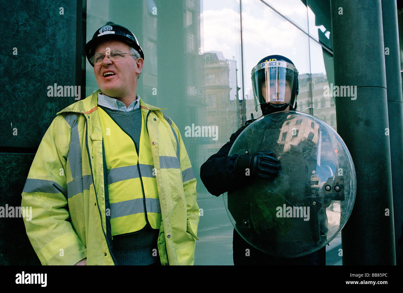 Ein Polizist neben einem Handwerker während der 2009 G20-Gipfel Protest in London Stockfoto