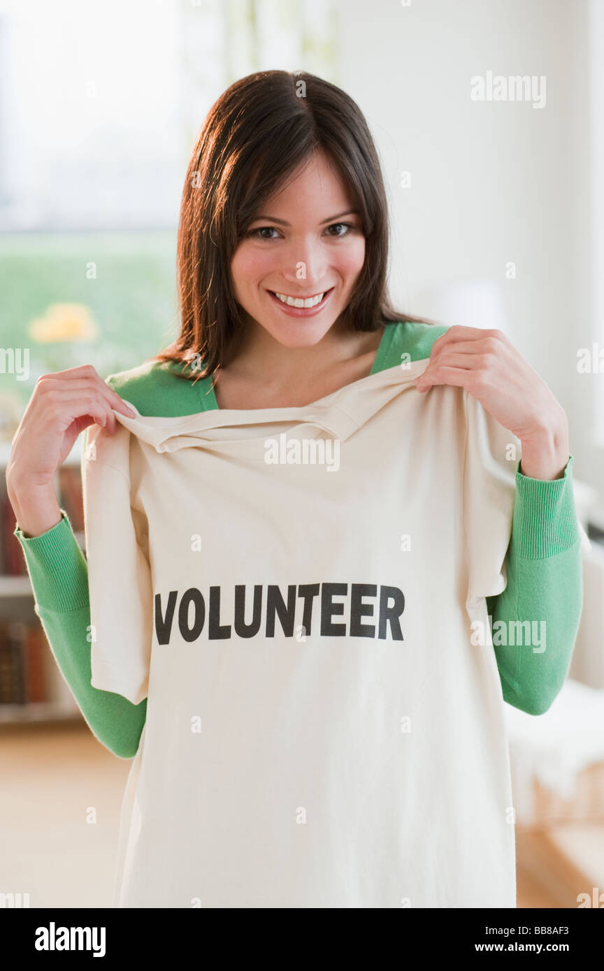 Mid-Adult-Frau zeigt T-shirt lesen Volunteer Stockfoto