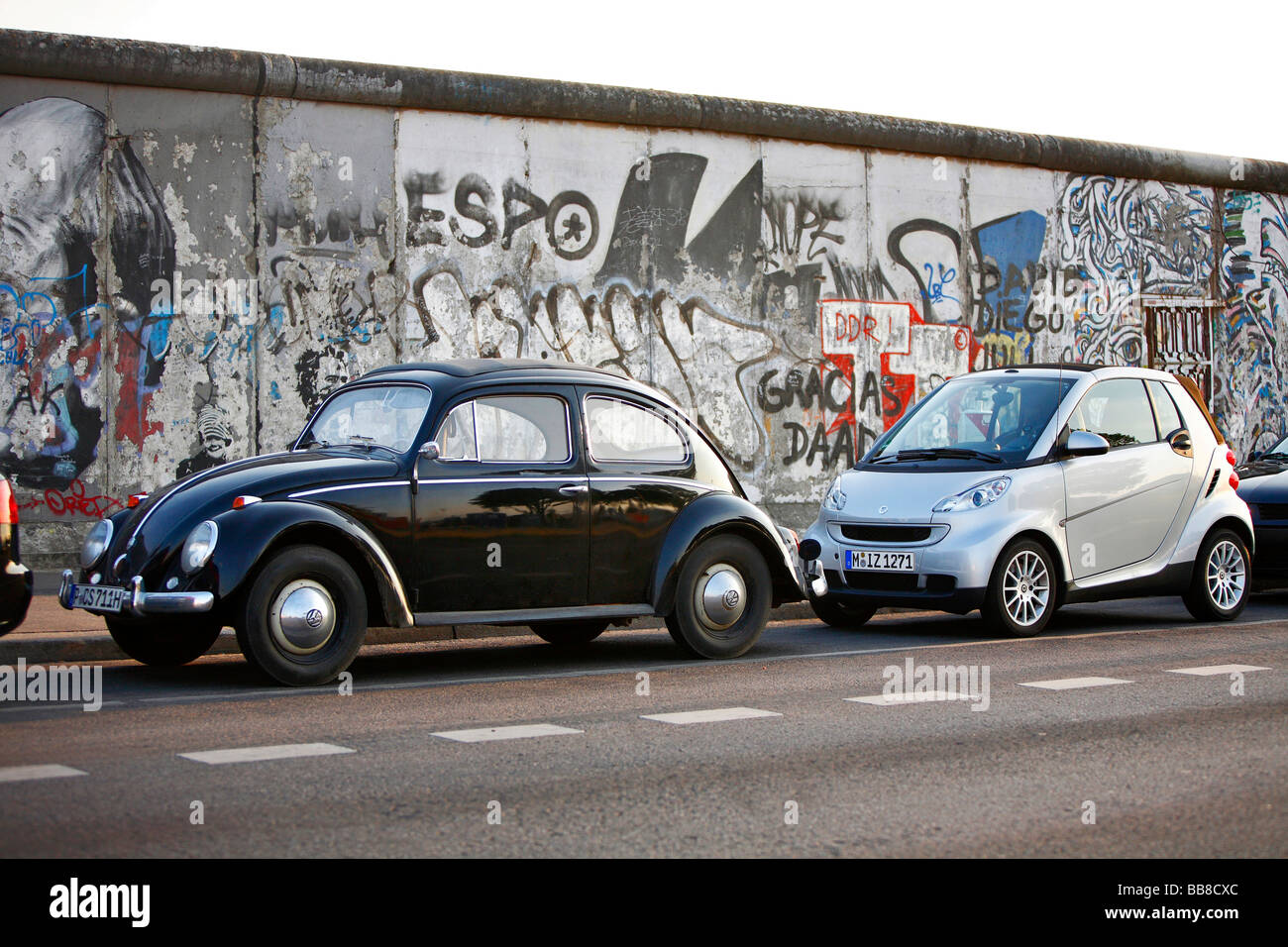 Generationen von Kleinwagen, VW Käfer und Smart Fortwo in der East Side Gallery in Berlin, Deutschland Stockfoto
