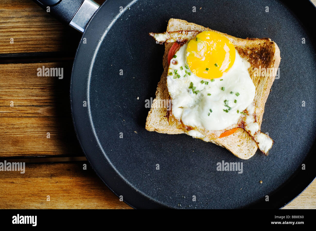 Spiegelei auf Toast mit Schnittlauch in einer Pfanne erhitzen  Stockfotografie - Alamy