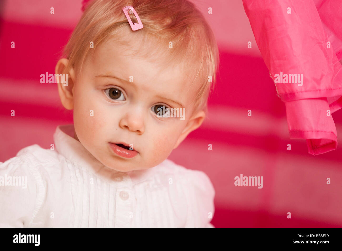 Porträt eines jungen Mädchens, 1 Jahr alt, vor einem rosa Spielzeug Zelt Stockfoto