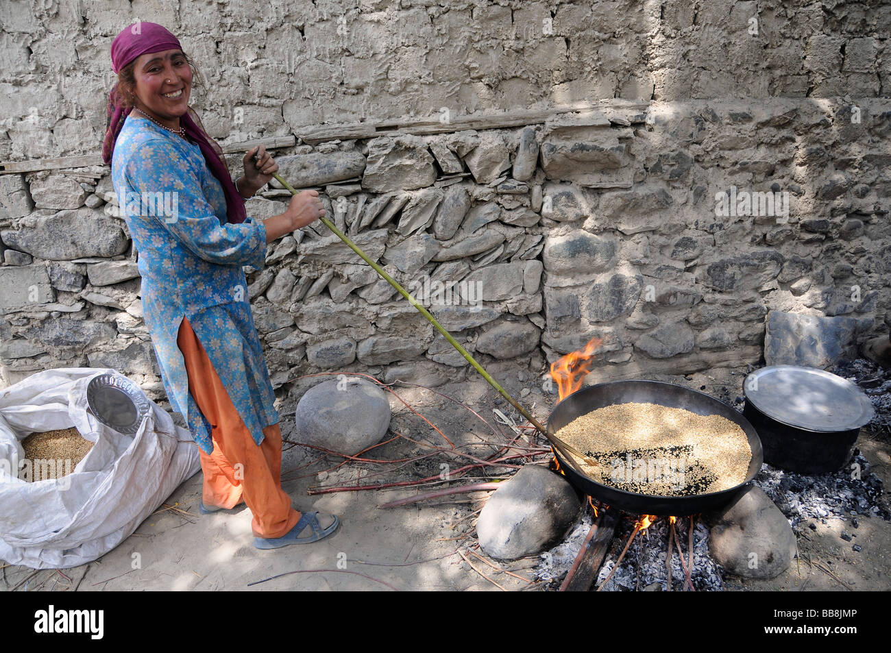 Ladakhi Frau Gerste rösten, für den Winter, Oasenstadt zu bewahren, Nubra Valley, Diskit, Himalaya, Ladakh, Indien Stockfoto