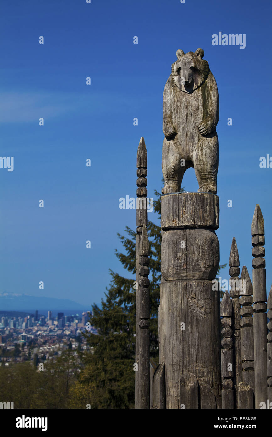 Tragen Sie Totem auf dem "Spielplatz der Götter" in Burnaby Park mit Vancouver, British Columbia, Kanada, im Hintergrund. Stockfoto