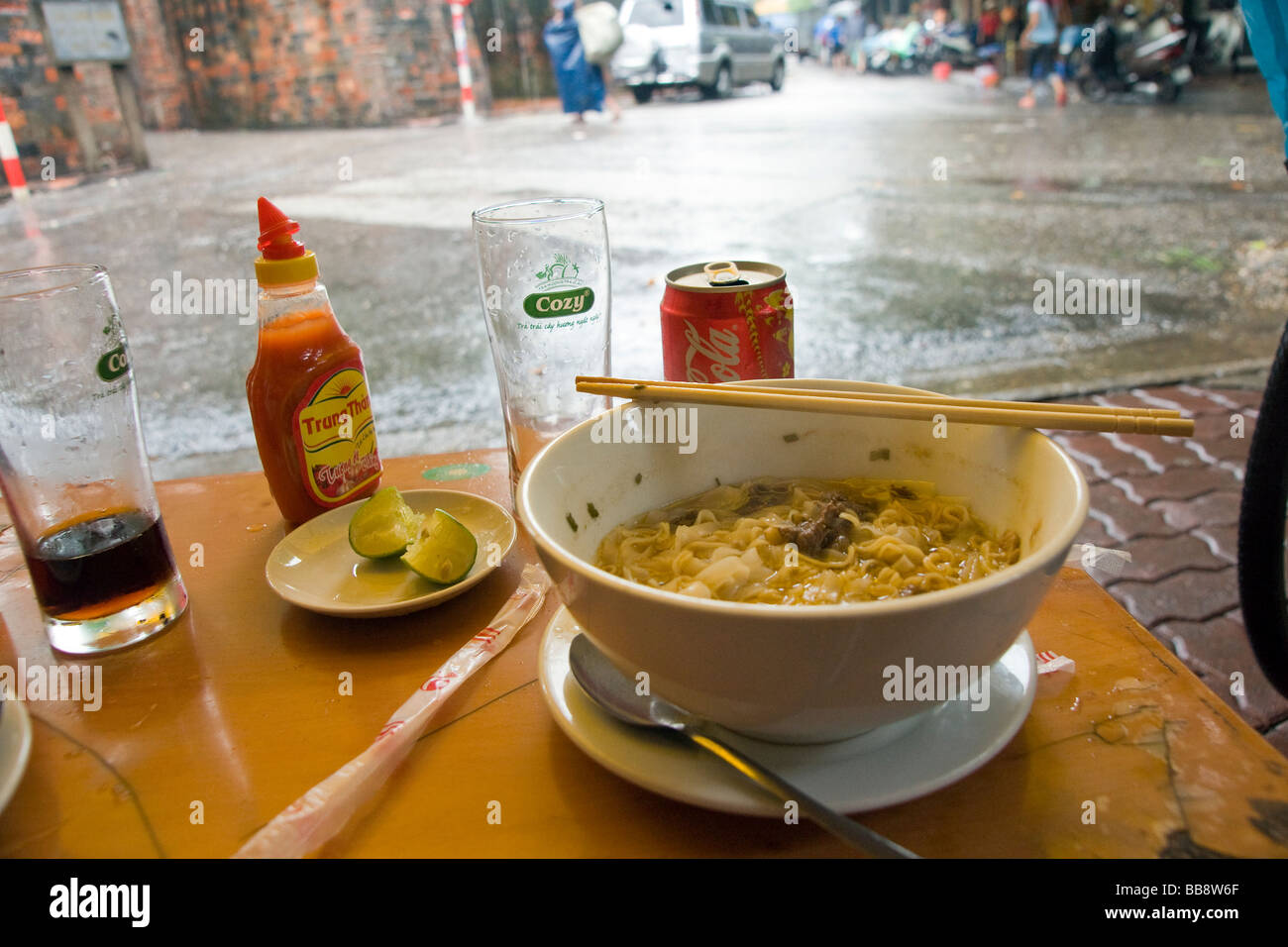 Eine Schüssel mit vietnamesische Nudeln und Getränke in einem typischen Straßencafé Stockfoto