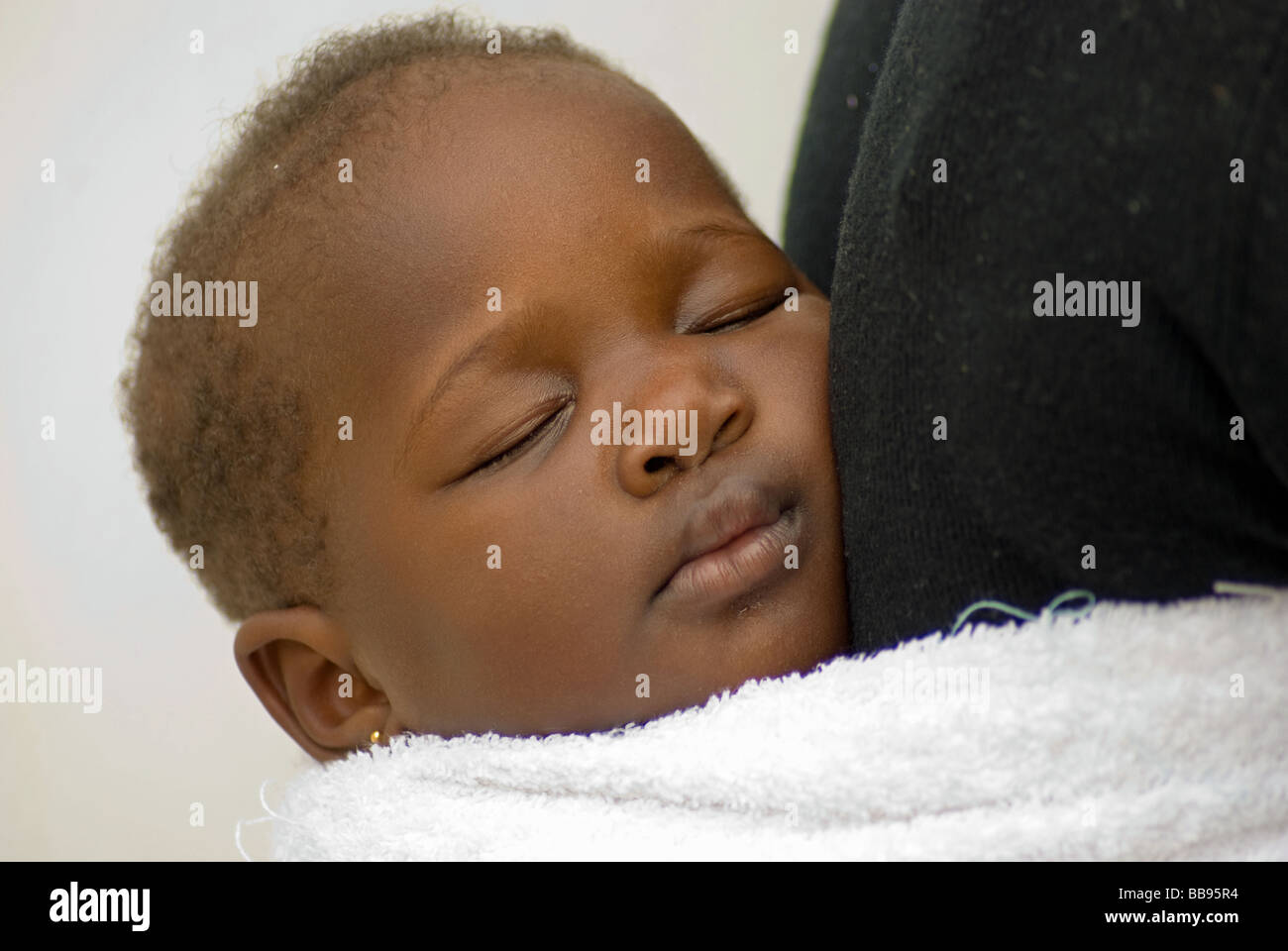 Porträt eines schlafenden Babys Simbabwes auf seine Mutter Rücken getragen. Stockfoto