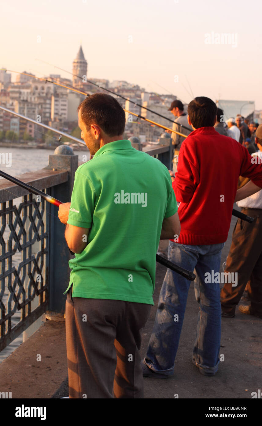 Istanbul Türkei Fischer Angeln auf der Galata-Brücke über das Goldene Horn bei der abendlichen Sonnenuntergang Dämmerung Stockfoto
