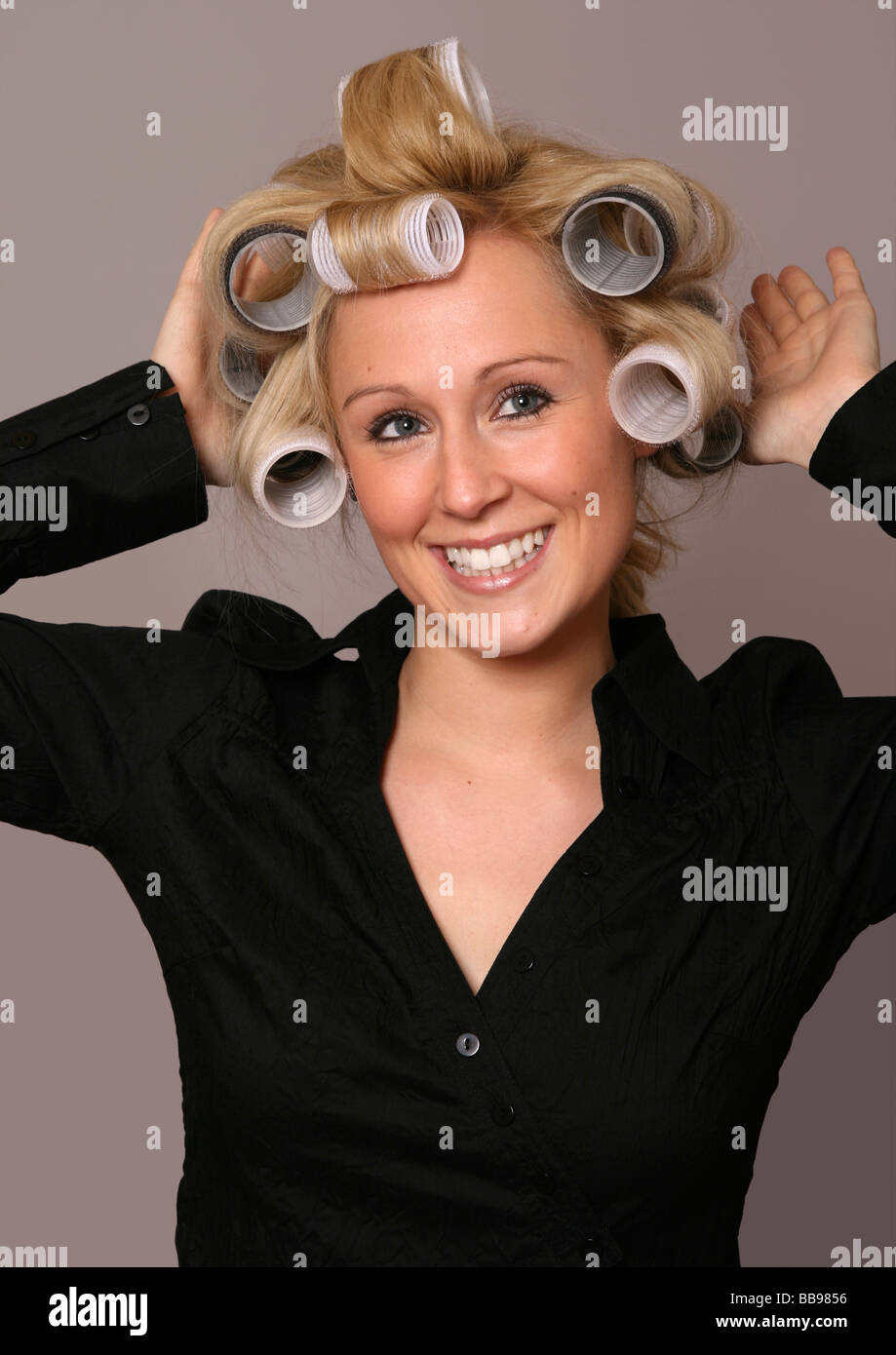 Glückliche Frau mit blonden Haaren tragen Rollen Stockfoto