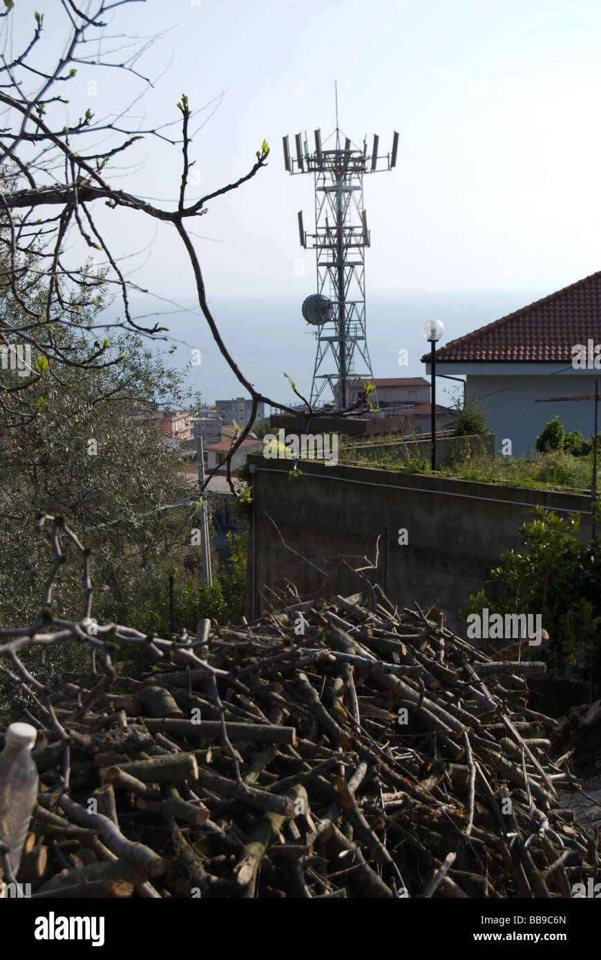 EINE ANTENNE FÜR DIE TELEKOMMUNIKATION, DIE OBERHALB DER HÄUSER Stockfoto