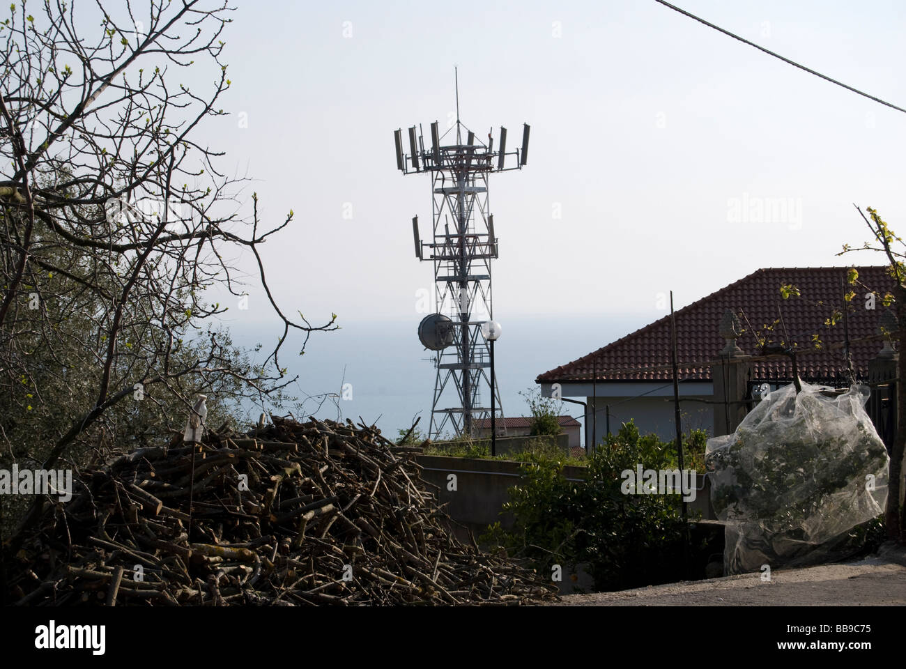 EINE ANTENNE FÜR DIE TELEKOMMUNIKATION, DIE OBERHALB DER HÄUSER Stockfoto