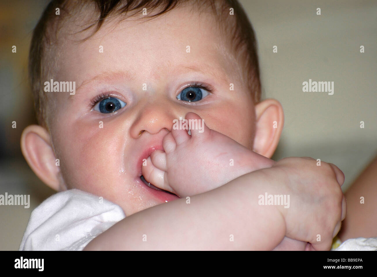 Babymädchen mit ihrem Fuß in den Mund Stockfoto