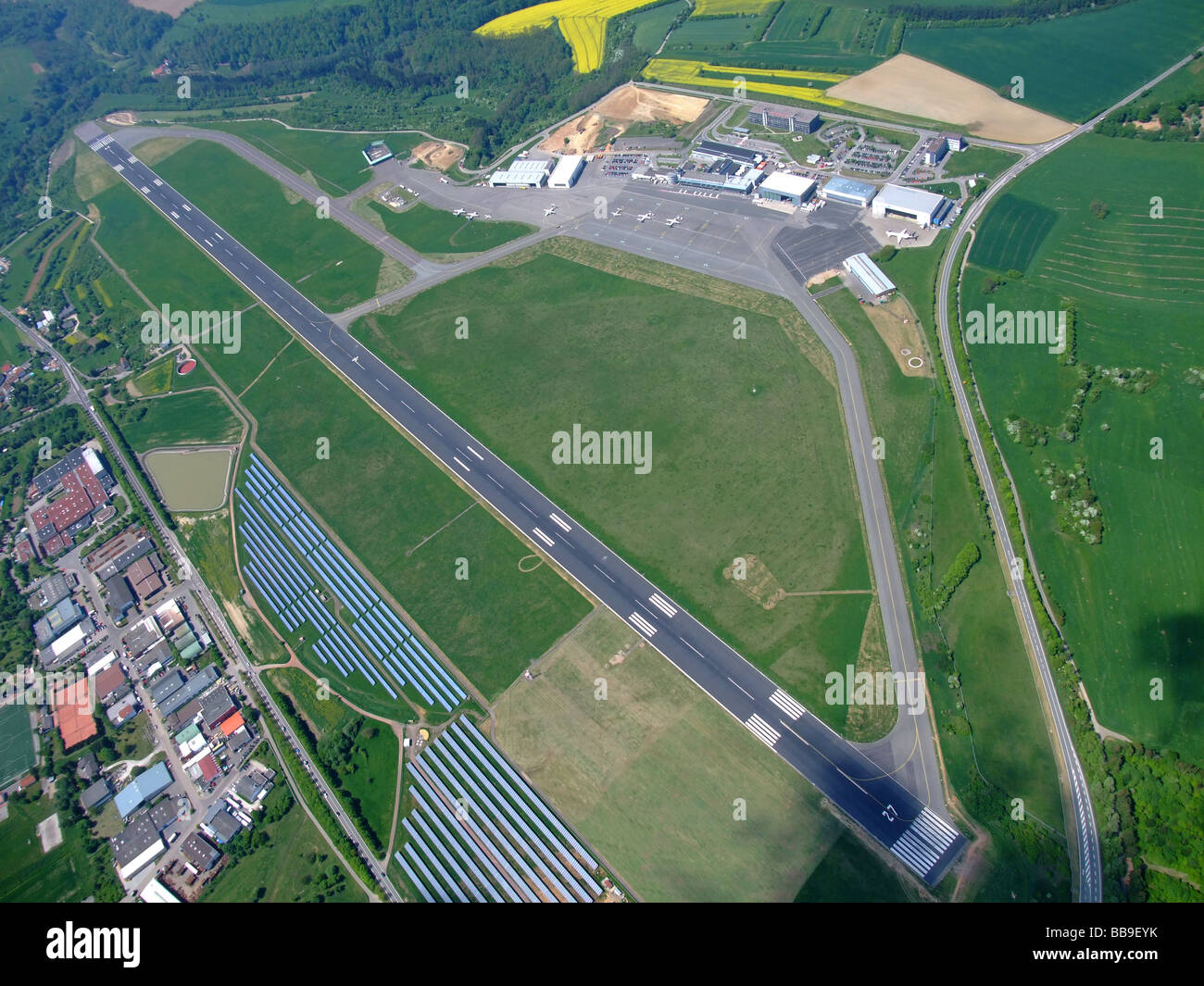 Luftbild von Terminals und Start-und Landebahn des Flughafens Saarbrücken Ensheim / Flughafen (Deutschland)-auf links ein Feld von Photovoltaik-Panels Stockfoto