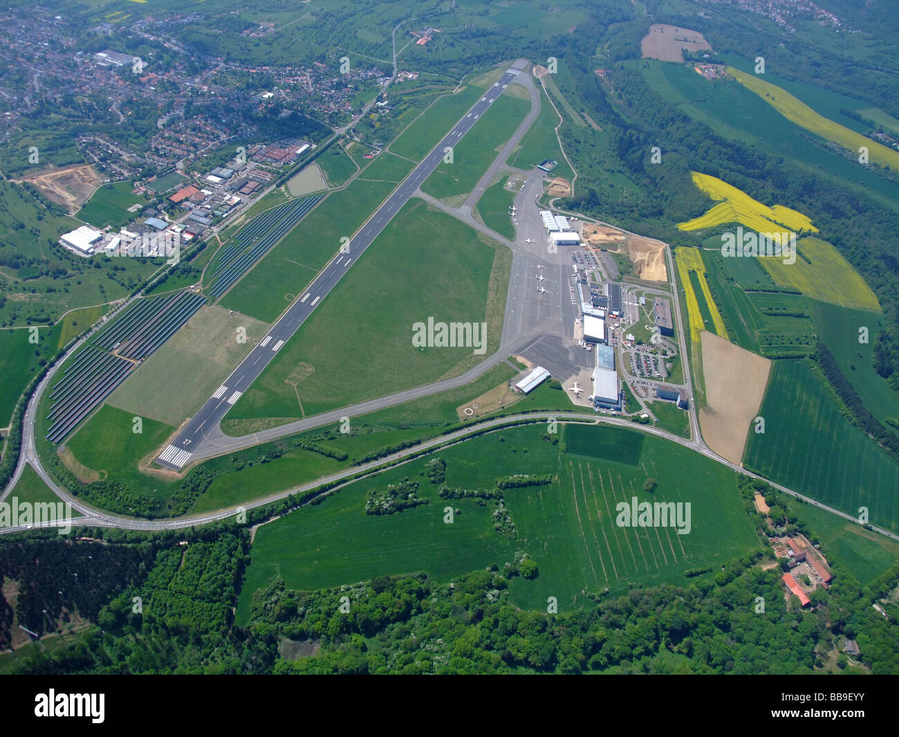 Luftbild von Terminals und Start-und Landebahn des Flughafens Saarbrücken Ensheim / Flughafen (Deutschland) - auf der linken Seite ein Feld von Photovoltaik-Panels Stockfoto