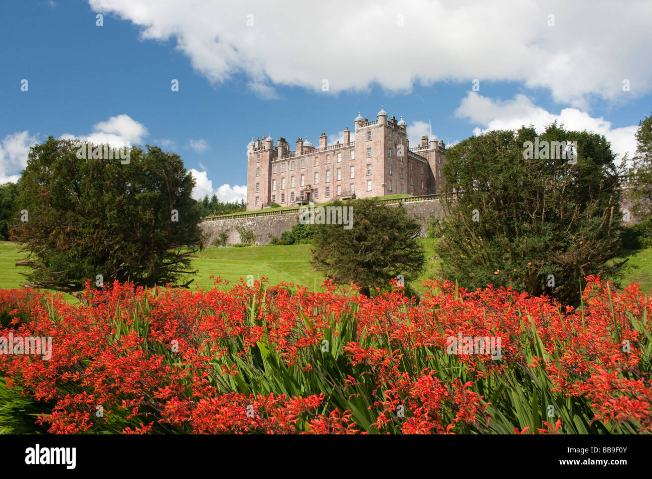 Drumlanrig Castle mit Montbrecia Blumen im Vordergrund Stockfoto