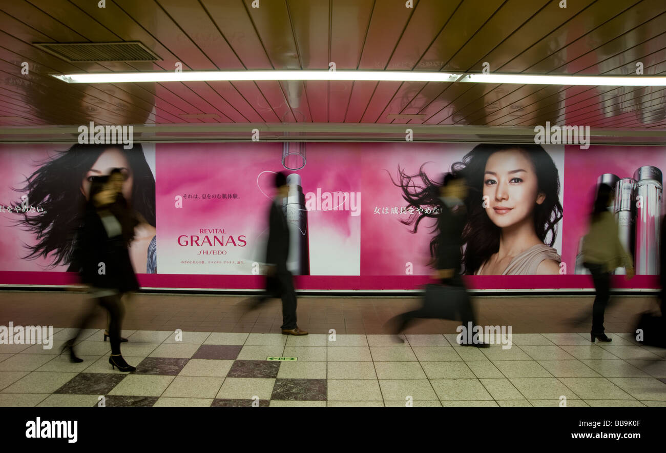 Fußgänger gehen vorbei an Wand Inserate in Unterführung in der Nähe von Shinjuku Station Shinjuku Bezirk Tokio Japan Stockfoto