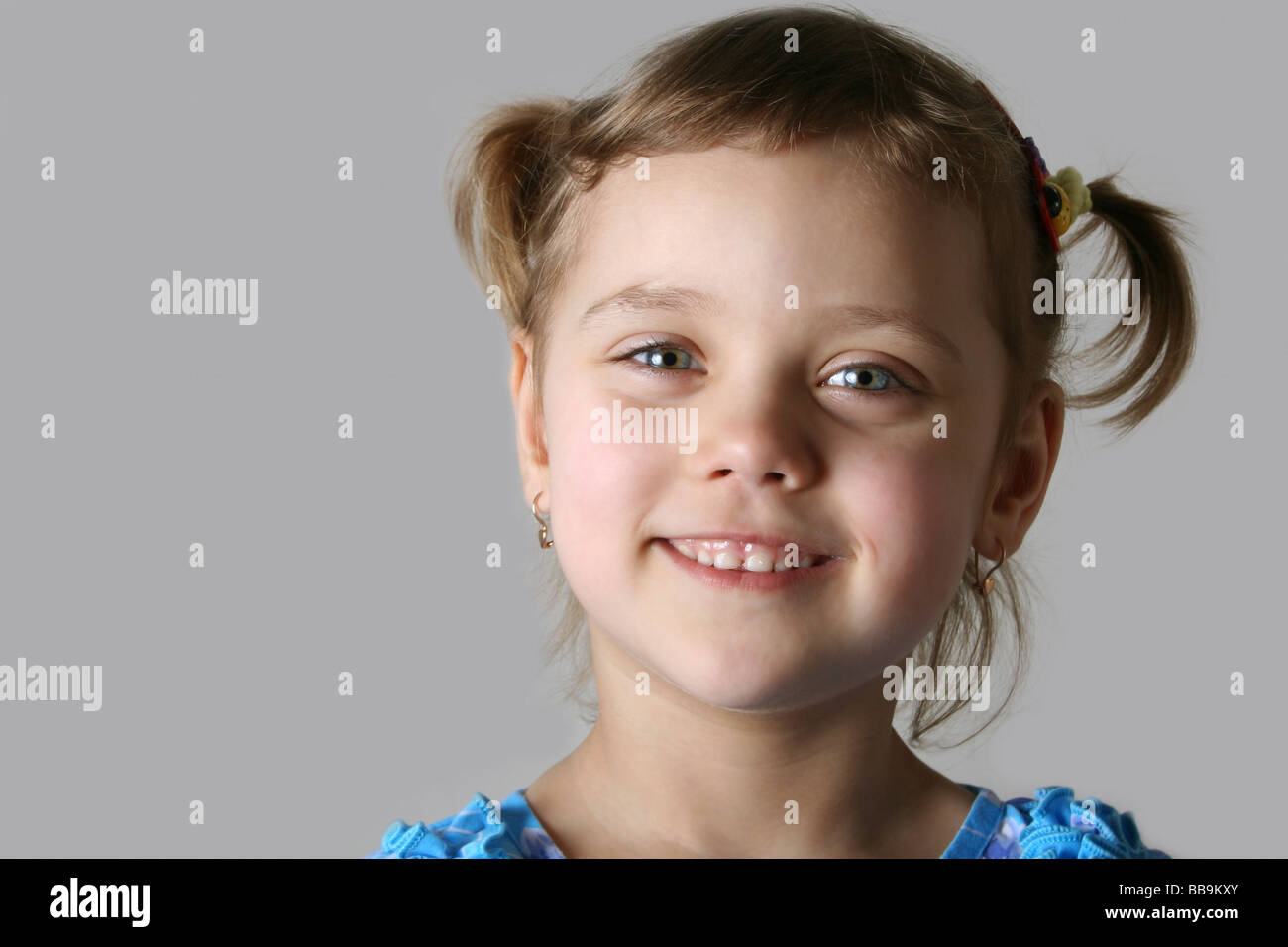 Gesicht der ziemlich lächelndes Mädchen Nahaufnahme grauen Hintergrund Stockfoto