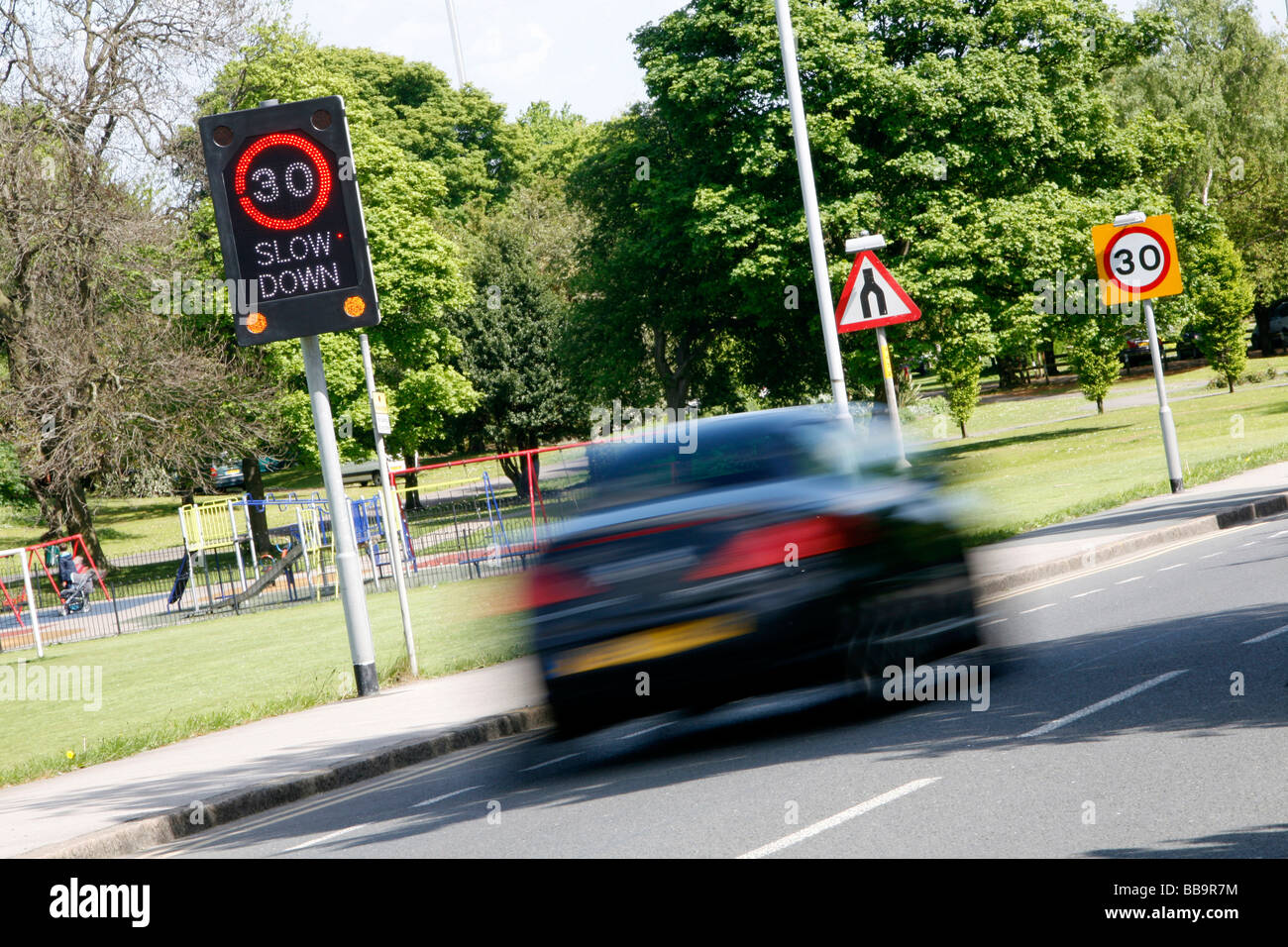 Schild am Straßenrand verlangsamen 30 Grenze beleuchtet. Stockfoto