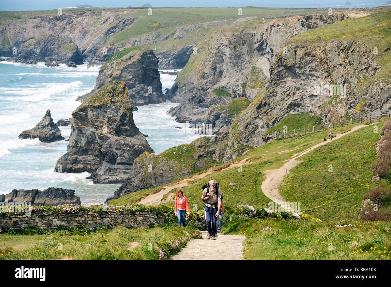 Küste Wanderer auf dem South West Coast Path nördlich von Newquay, Cornwall. Hintergrund der Felsnadeln und Klippen von Bedruthan Steps. Stockfoto
