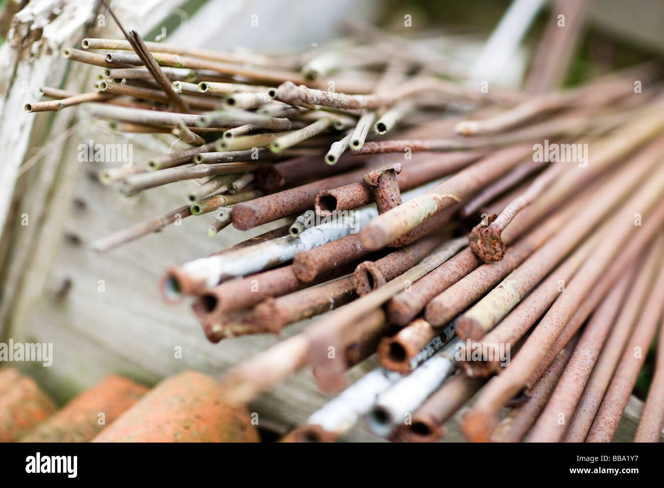 Ein Bündel von rostigem Metall, Bambus und Weide Einsätze in einer Holzkiste auf einer Zuteilung Stockfoto