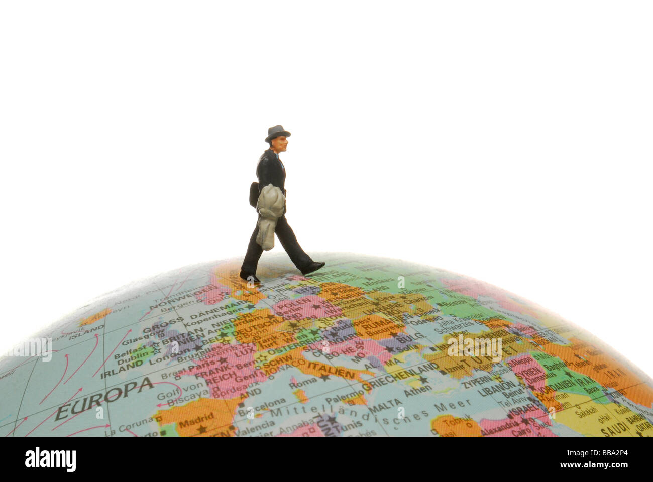 Miniatur-Abbildung eines Geschäftsmannes zu Fuß auf einem Globus, symbolisches Bild für den internationalen Handel Stockfoto