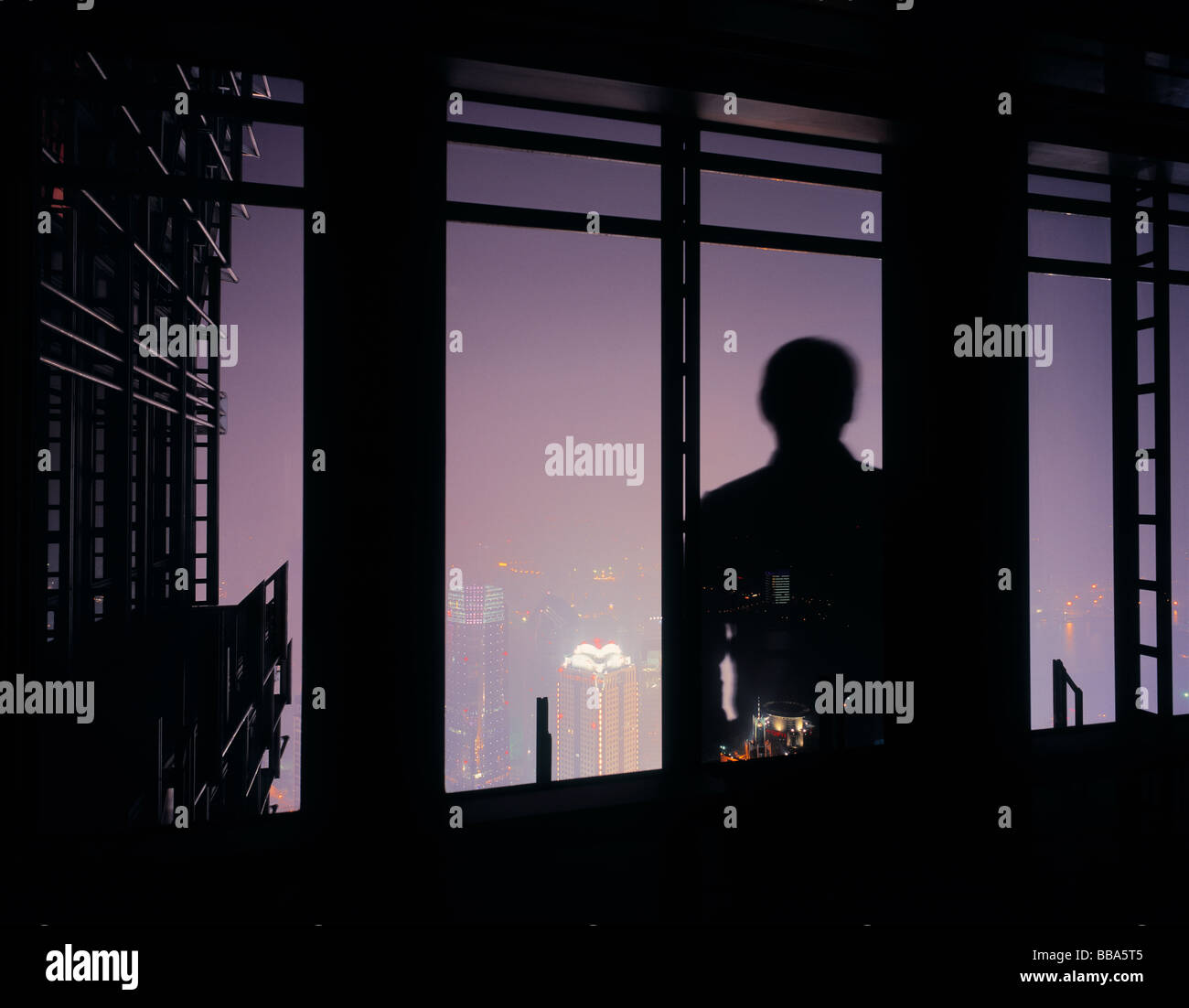 Silhouette des Mannes vor Fenster mit Blick auf die Skyline von Shanghai, China. Stockfoto