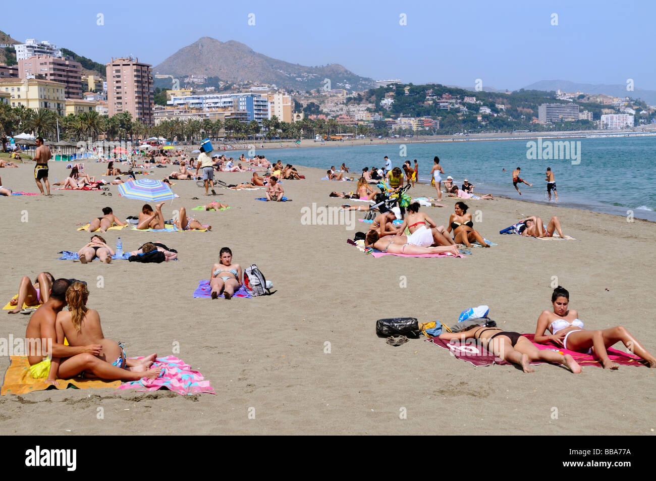Sonnenbaden am Strand mit Mittelmeer in der Stadt Malaga Costa del Sol Spain Stockfoto
