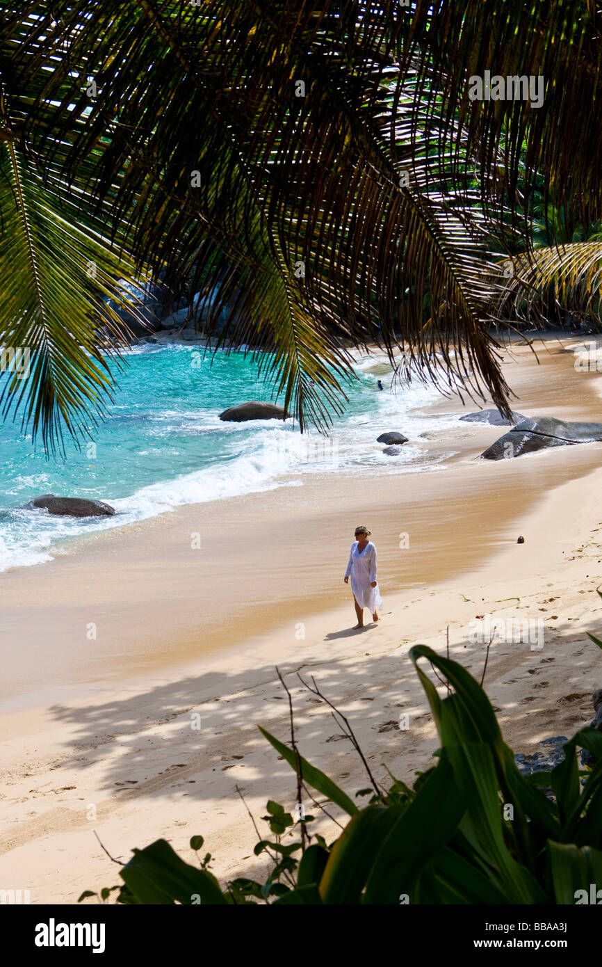 Frau am Strand entlang trägt eine Tunika, Insel Mahé, Seychellen, Indischer Ozean, Afrika Stockfoto