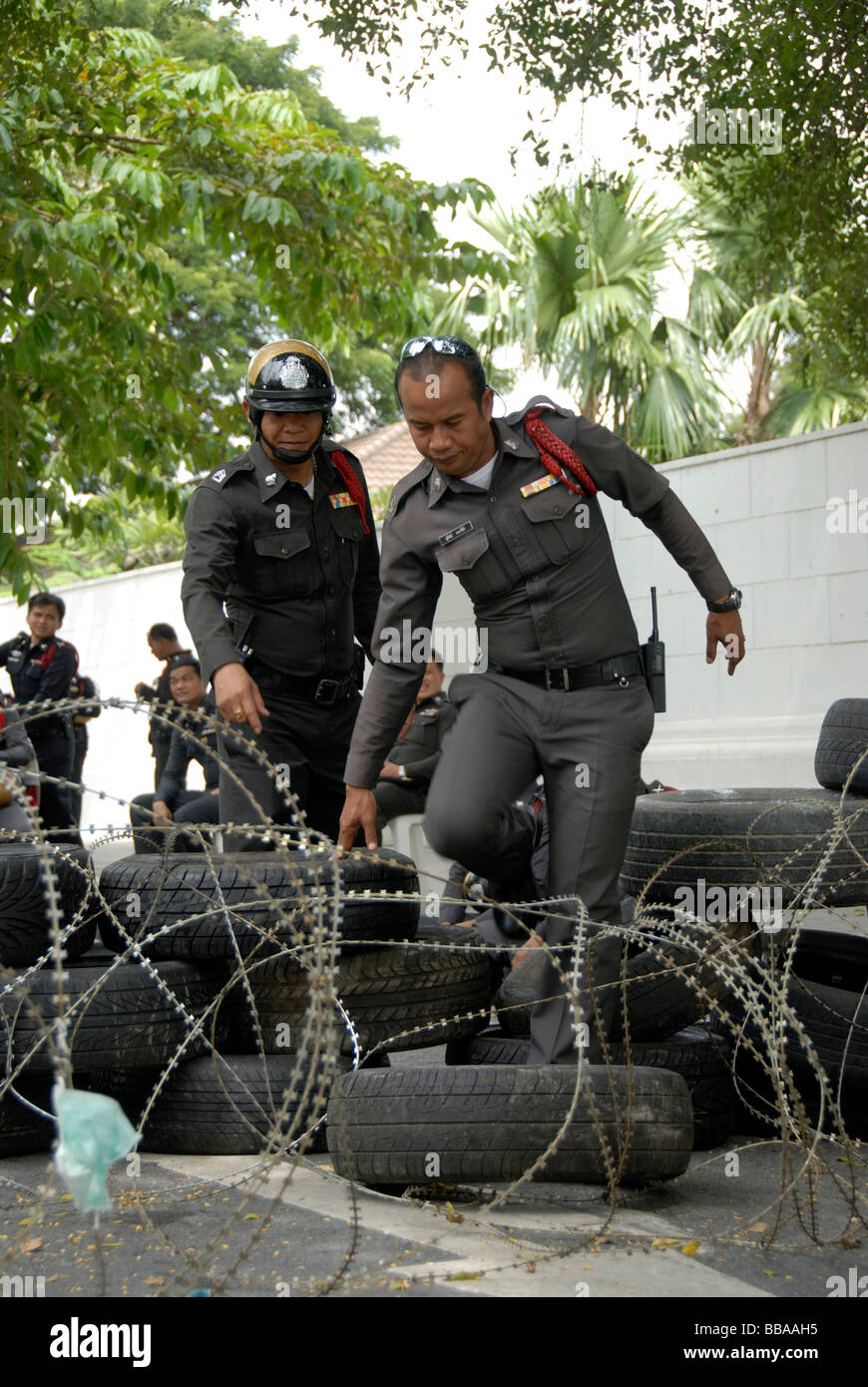 Demonstration, Polizisten Überklettern Straßensperre von Stacheldraht und Auto Reifen, Bangkok, Thailand, Südostasien Stockfoto