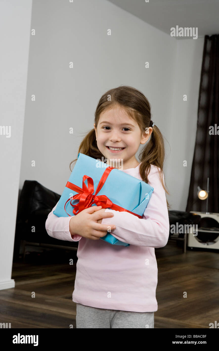 Ein junges Mädchen hält ein verpacktes Geschenk Stockfoto