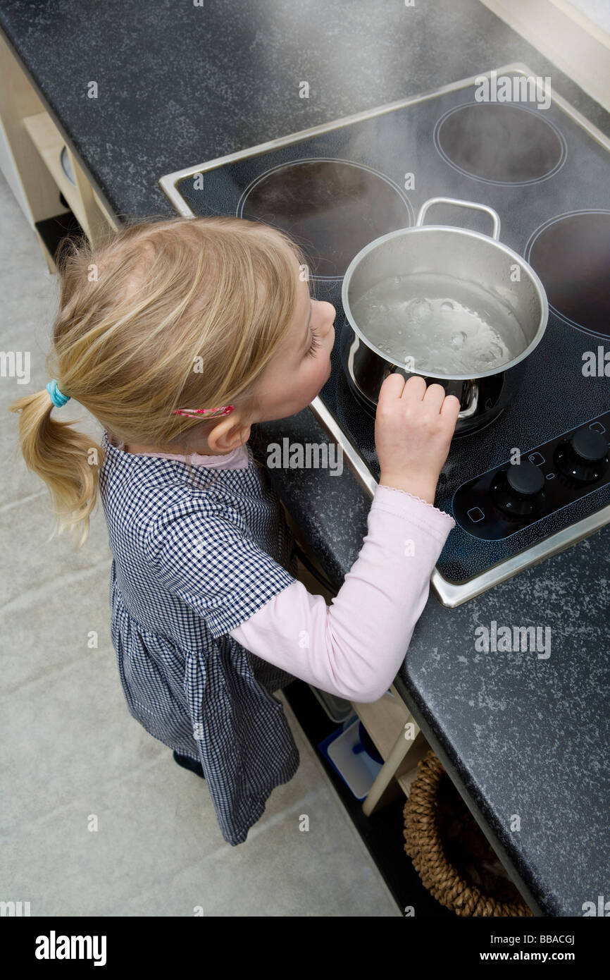 Ein junges Mädchen, packte einen Topf mit kochendem Wasser Stockfoto