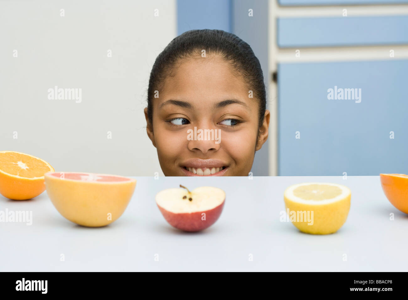 Eine junge Frau über einen Zähler bei Fruit spähen Stockfoto