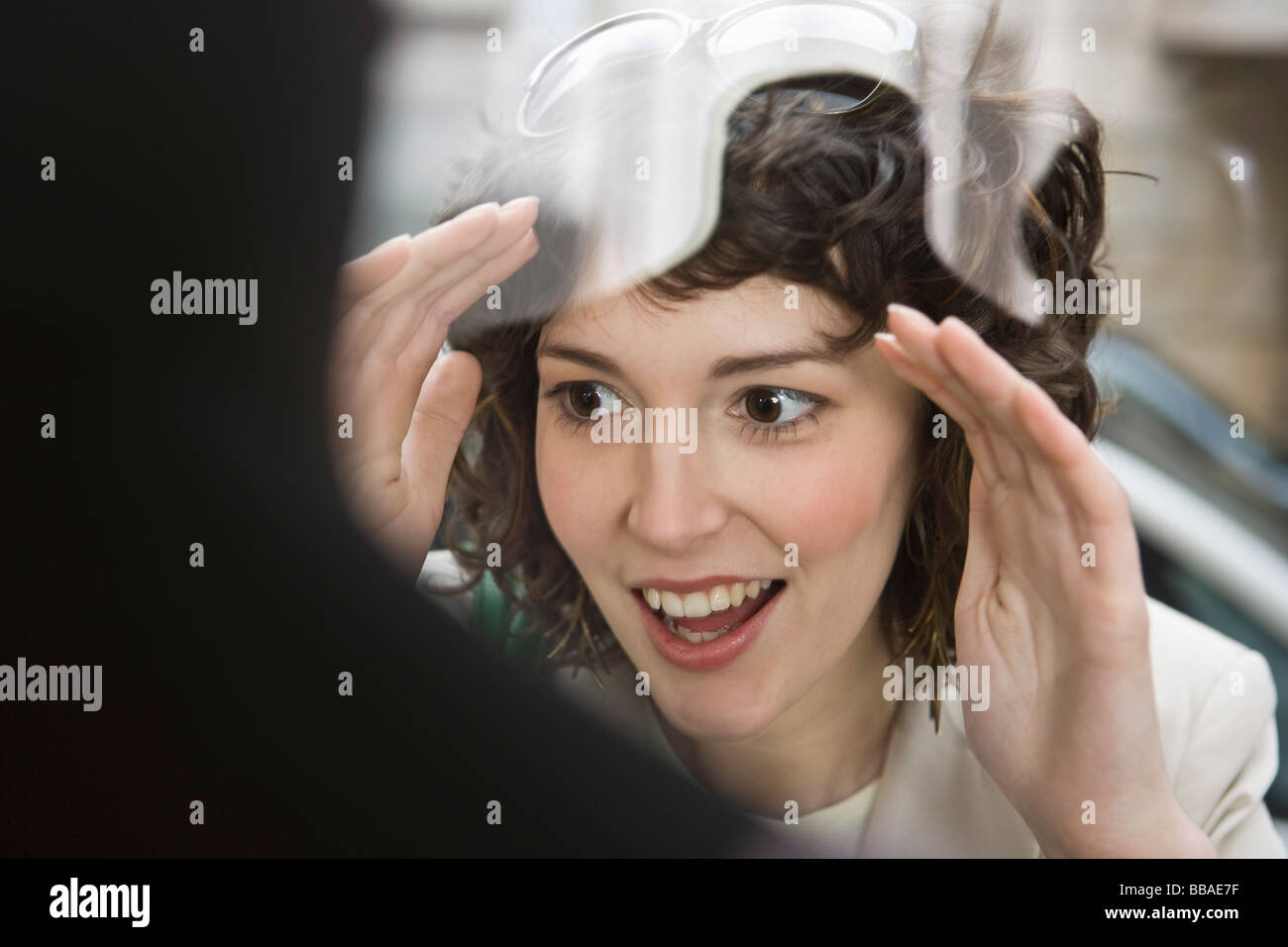 Eine Frau, die begeistert durch ein Schaufenster Stockfoto