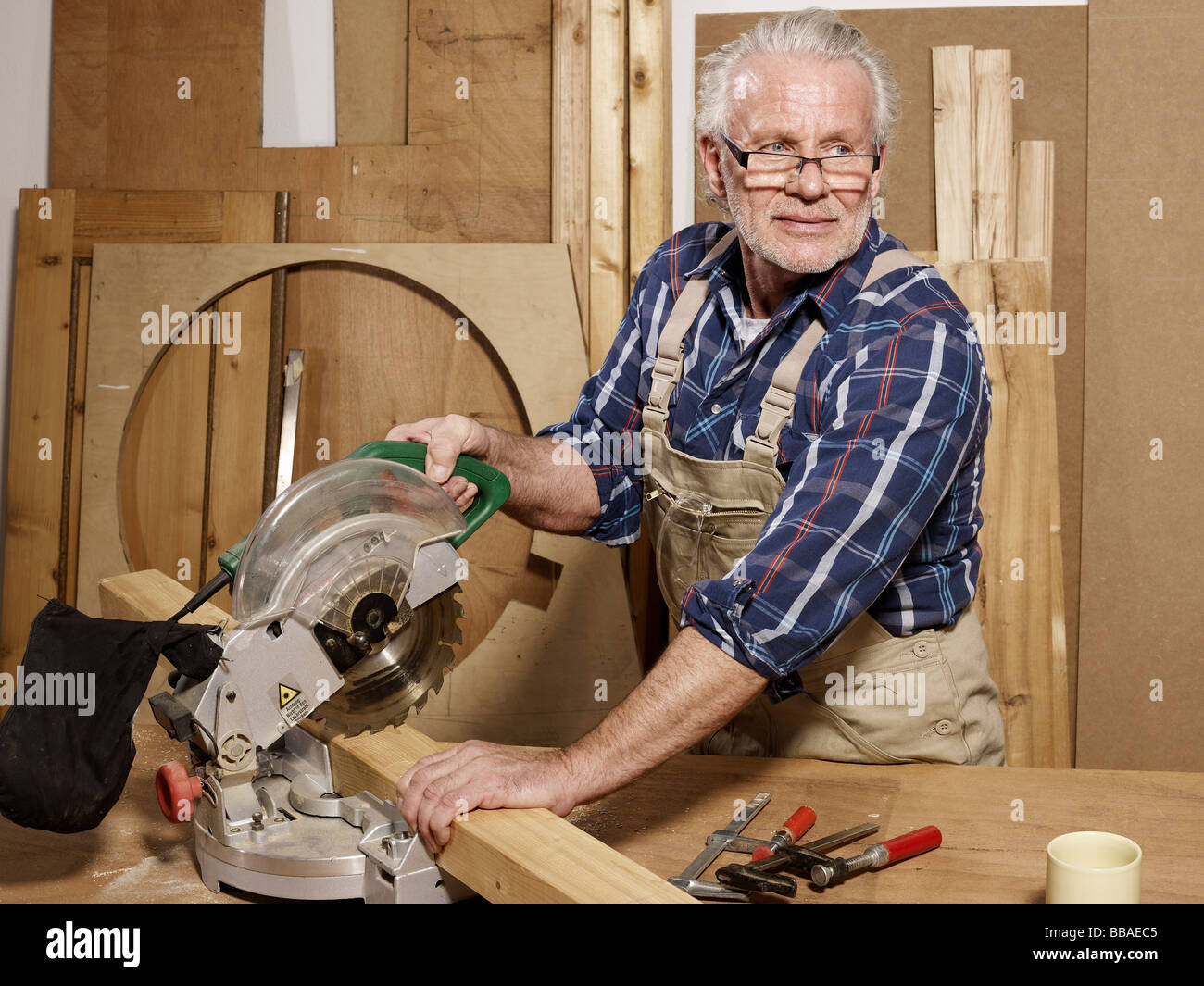 Ein Mann, Sägen von Holz in einem workshop Stockfoto