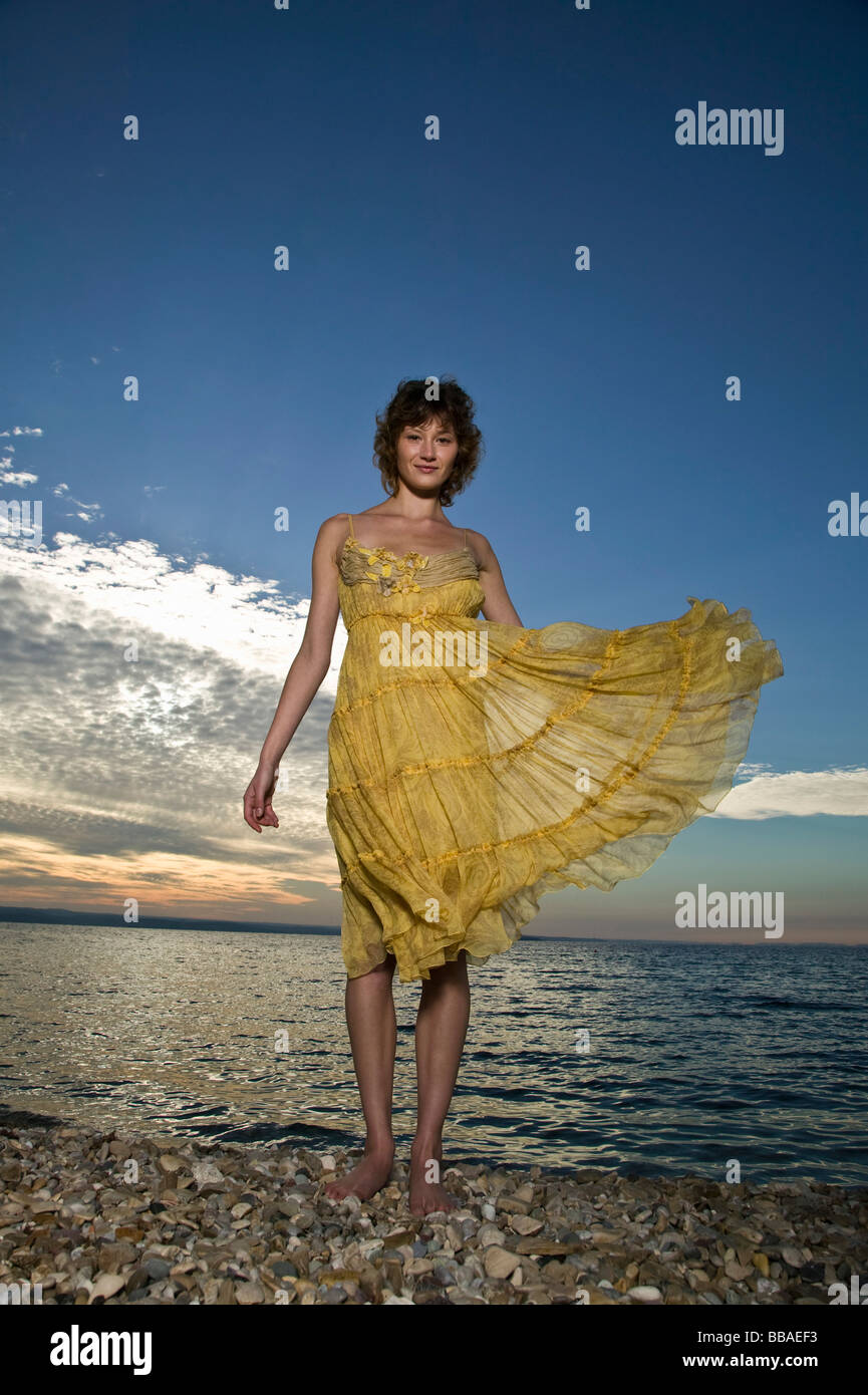 Eine Frau trägt ein Kleid steht am Meer Stockfoto