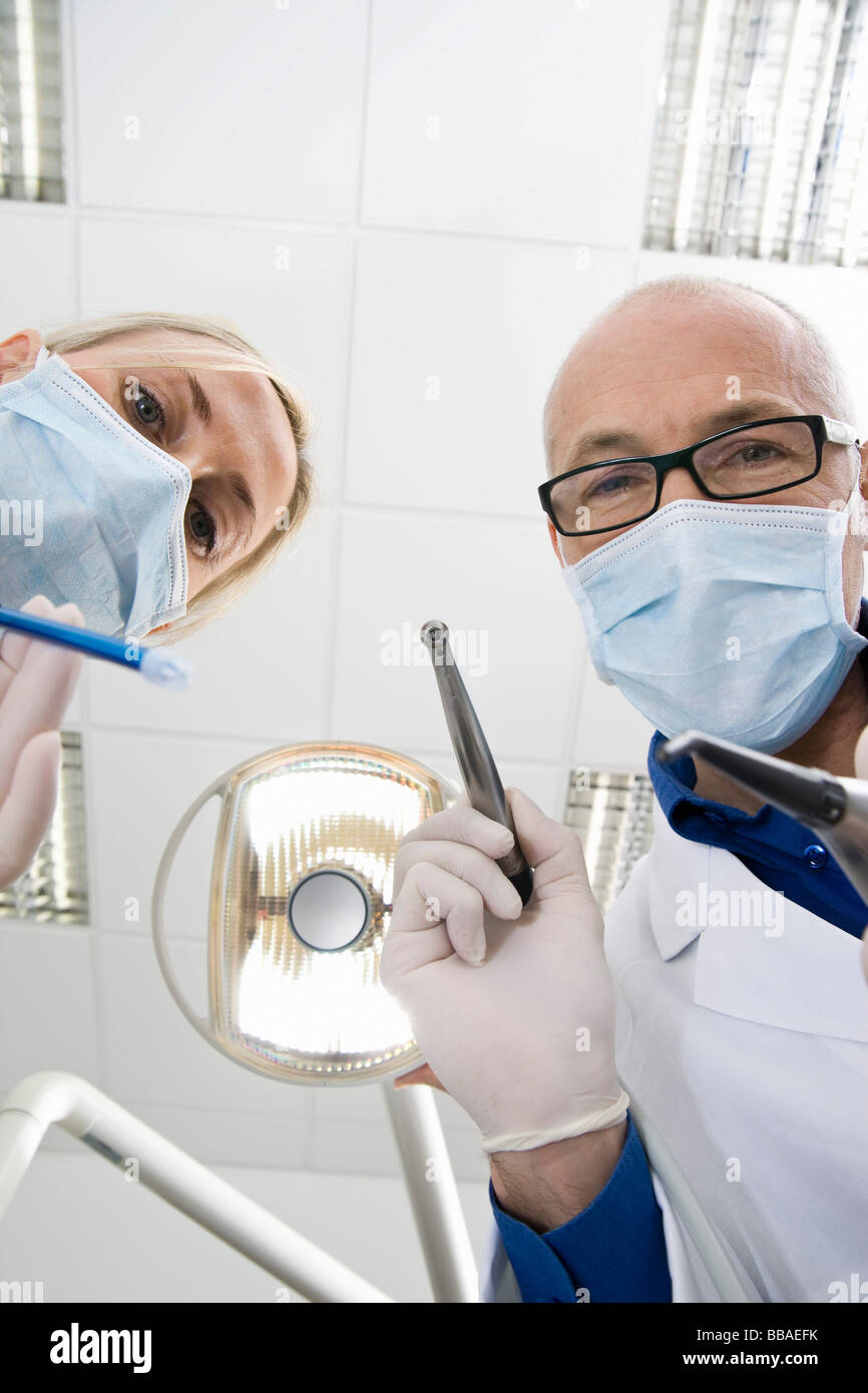 Blick von unten auf ein Zahnarzt und ein Assistent hält Dentalwerkzeuge Stockfoto