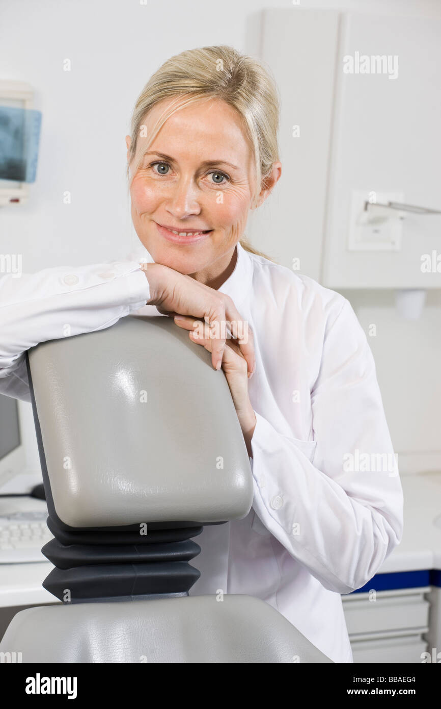 Porträt von Zahnmedizinische Fachangestellte sitzt hinter einem Behandlungsstuhl Stockfoto