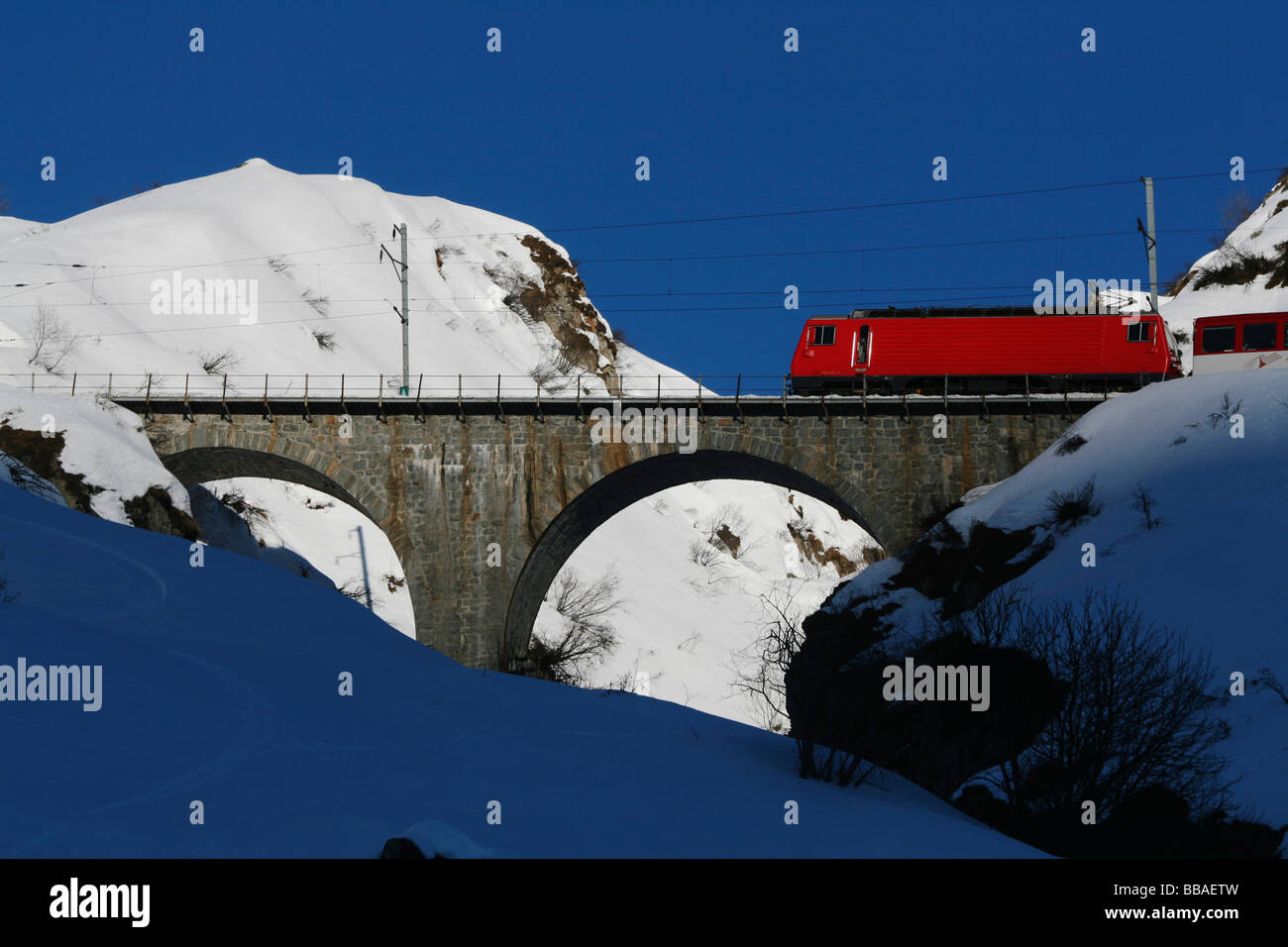 Glacier Express Zug Kreuzung Brücke über verschneite Berge, Graubündens, der Schweiz Stockfoto